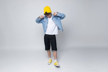 Kıvırcık çocuk, gri arka planda..