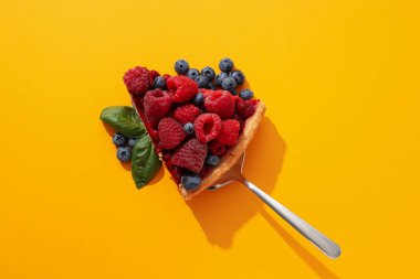 Sarı arka planda ahududu ve yaban mersinli turta.