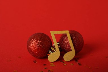 Kırmızı zemin üzerinde top olan altın müzik notaları