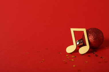 Kırmızı zemin üzerinde top olan altın müzik notaları