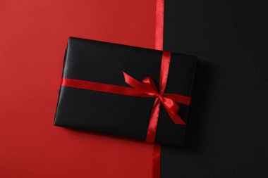 Kırmızı arkaplanda kurdeleler ve hediye kutusu, üst görünüm