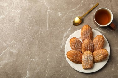 Madeleine kekleri, kaşık ve fincan çay gri arka planda, metin için boşluk