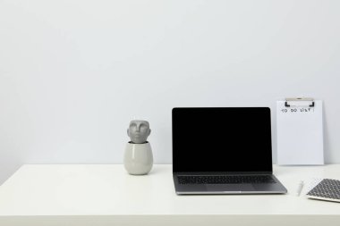 Beyaz bir masada açık bir laptop.