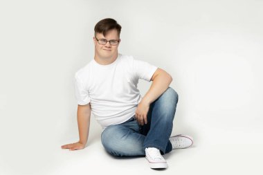 Down sendromlu bir çocuk kameraya poz veriyor.