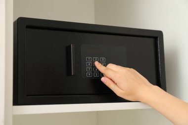 Dairedeki raflarda siyah bir kasa var.