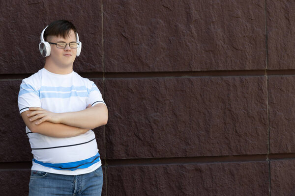 Мальчик с синдромом Дауна слушает музыку в наушниках