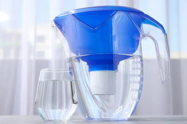 A water filter with a glass on a light background