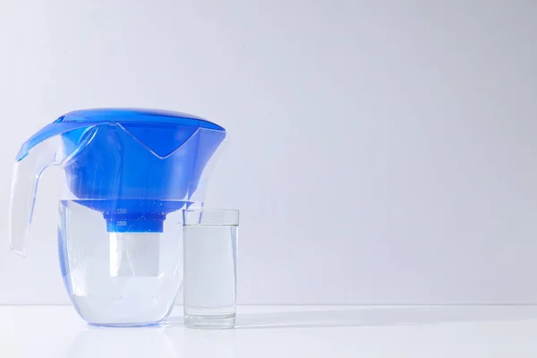 A water filter with a glass on a light background