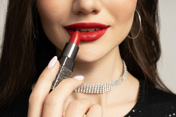 Привлекательная девушка красит губы крупным планом.