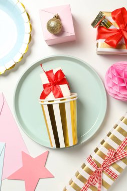 Tabaklar, hediye kutuları ve beyaz arka planda kağıt bardaklar, üst görünüm