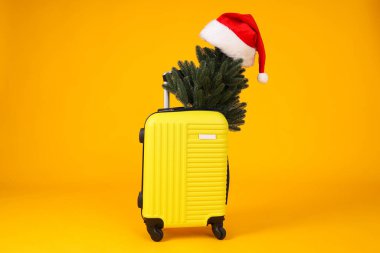 Noel ağacı dallı sarı bir bavul.