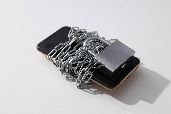 The smartphone is encased in a chain with a lock