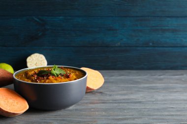 Tatlı patates püresi kasede ve sebzeler ahşap arka planda, metin için yer var.