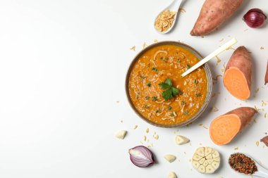 Tatlı patates püresi ve kaşık kasede ve malzemeler beyaz arka planda, mesaj için yer