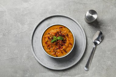 Tatlı patates püresi kasede, tabak, kaşık ve tuz gri arka planda, üst manzara