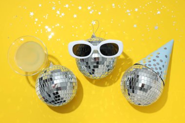 Sarı arka planda gözlüklü disko topları