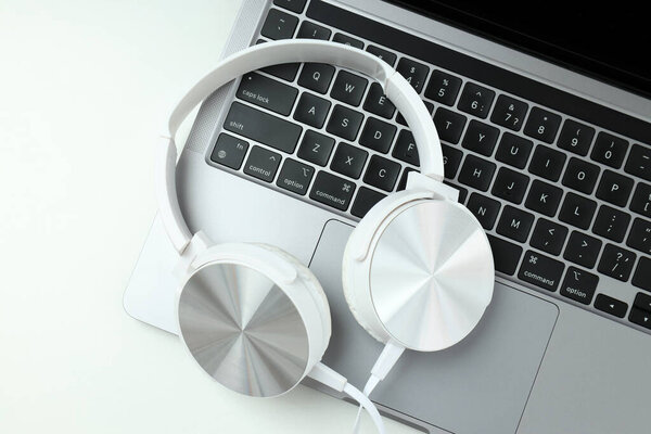 Большие наушники, на столе с ноутбуком.