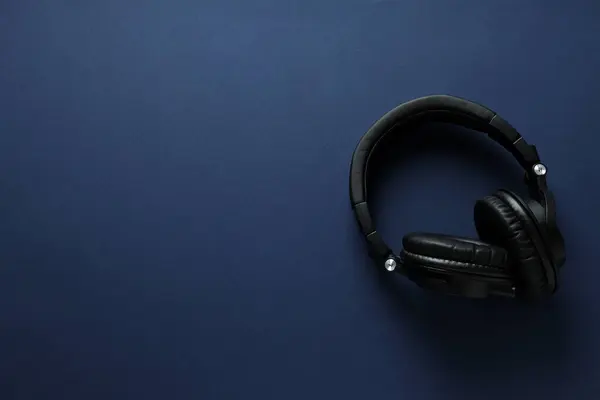 Over-ear, black headphones, on a dark background.
