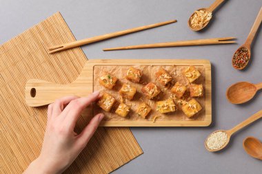 Tahtada kaşık kaşık ile kızarmış tofu.