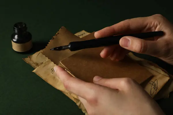 Old love letters in human hands, on a dark background.