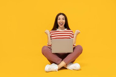 Karton kutulu mutlu kız, bir paket, sarı arka planda..