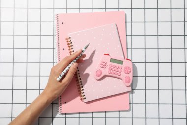 Not defterleri, hesap makinesi ve kalem elinde ışık arkaplanı, üst görünüm