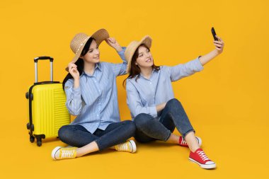 Seyahat için bavulları olan iki kız kardeş.