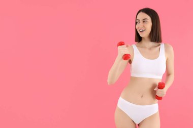 İç çamaşırlı, halterli, ince bir kız spor yapıyor..