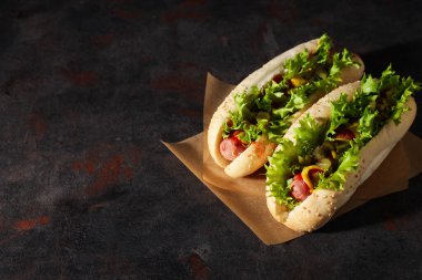 Koyu gri arkaplan üzerinde sosisli sandviç, metin için boşluk