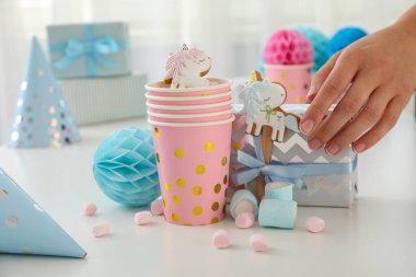 Hediye kutusu, kurabiyeli kağıt bardak, lokum ve arka planda hafif bir el.