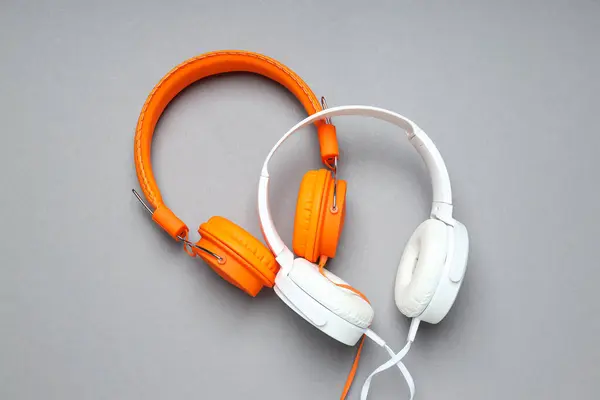 A pair of over-the-ear headphones on a light background.