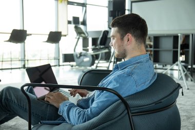 Neşeli genç bir girişimci modern bir çalışma alanında çalışır.