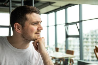 Ofiste pencereden dışarı bakan çekici genç adam.