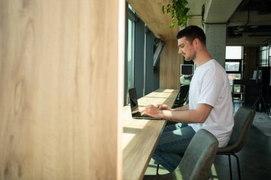 Neşeli genç bir girişimci modern bir çalışma alanında çalışır.