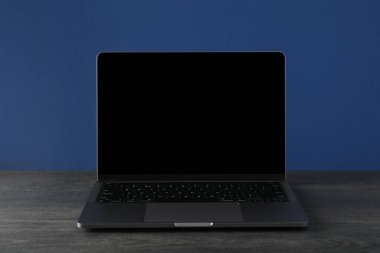 Karanlık bir masada açık bir laptop.