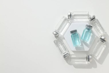 Beyaz arka planda aşısı olan cam şişeler, metin için boşluk