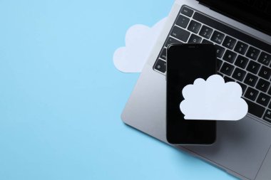 Mavi arka planda beyaz bulutlu siyah akıllı telefon.