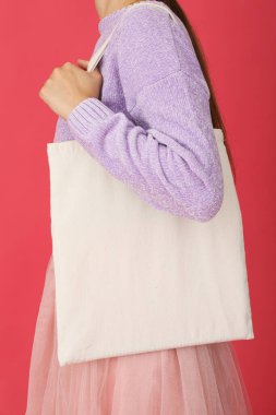 Bir kadının omzunda beyaz bir çanta.