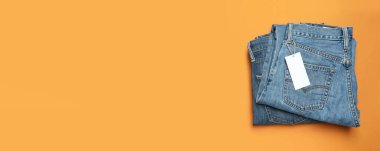 Ukrayna, Kyiv, 28.10.2023 turuncu arka planda etiketli katlanmış kot pantolon.