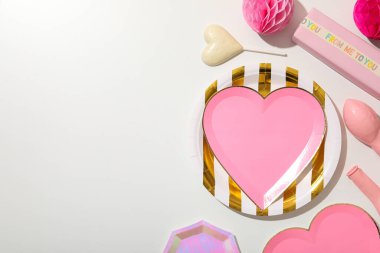 Açık arkaplanda pembe kalp şeklinde bir plaka..