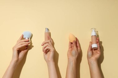 Kadınların elinde yüz için dekoratif kozmetik ürünler..