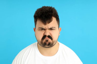 Mavi arka planda üzgün şişman bir adam..