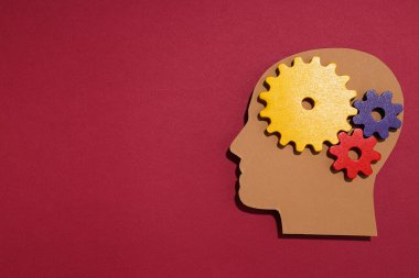 Kırmızı zemin üzerinde dişliler olan kağıt insan kafası.