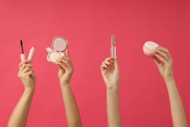 Kadınların elinde yüz için dekoratif kozmetik ürünler..