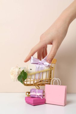 Arka planda çiçekler olan alışveriş arabası..