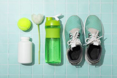 Spor kıyafetleri ve aksesuarlar, çiçeklerle, mavi bir arka planda..