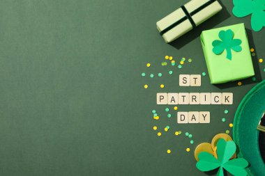 Metin, yeşil şapka, hediye kutuları, yonca ve altın paralar yeşil arka planda, metin için boşluk