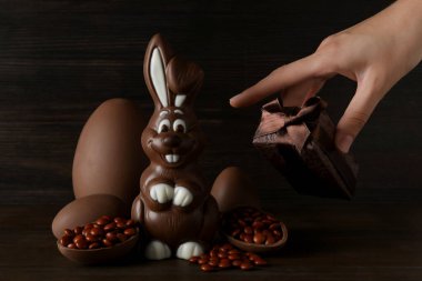 Koyu arkaplanda çikolatalı tavşan olan çikolatalı yumurtalar.