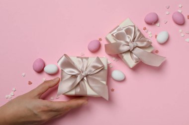 Pembe arka planda hediyeleri olan çikolatalı yumurtalar.