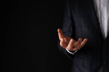 İş adamının eli siyah bir arkaplanda.